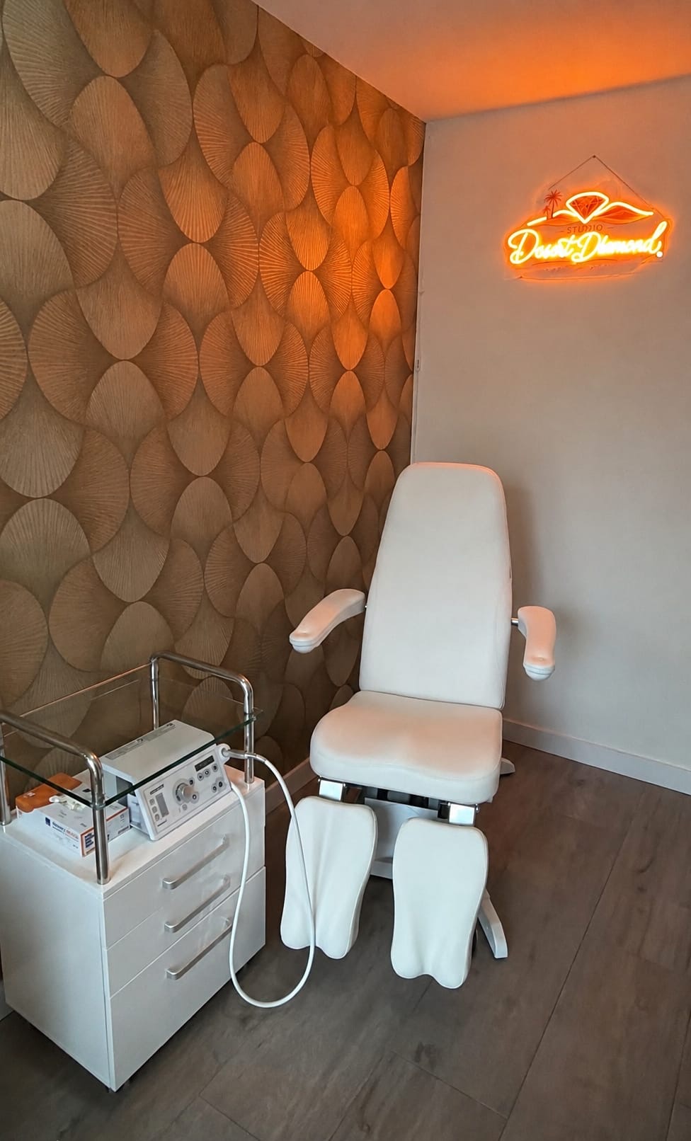 Pedicurestoel voor de gouden wand met het neonbord van Studio Desert Diamond